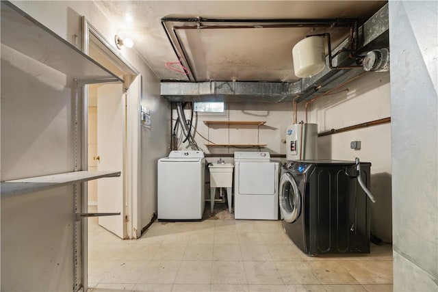 laundry room featuring water heater, washer and clothes dryer, and sink