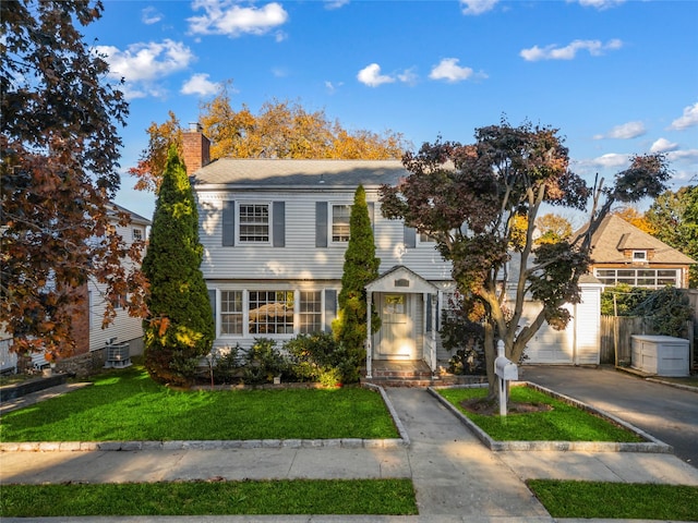 view of front of property featuring a front yard, a garage, and central air condition unit