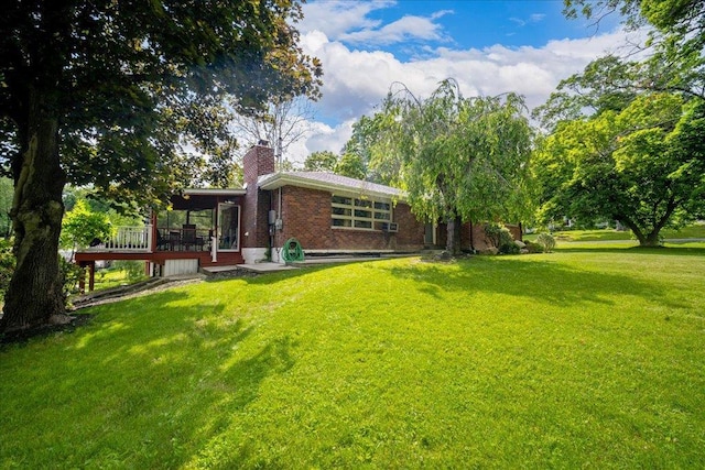 back of house with a sunroom and a lawn