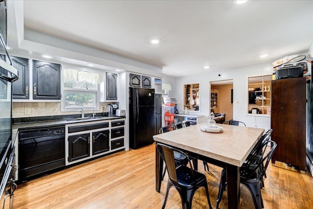 kitchen featuring sink, light hardwood / wood-style floors, and black appliances