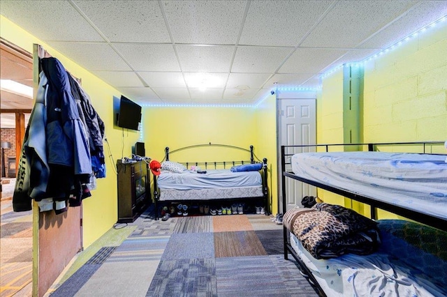 carpeted bedroom with a drop ceiling