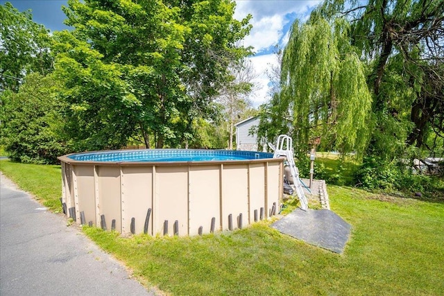 view of swimming pool with a yard