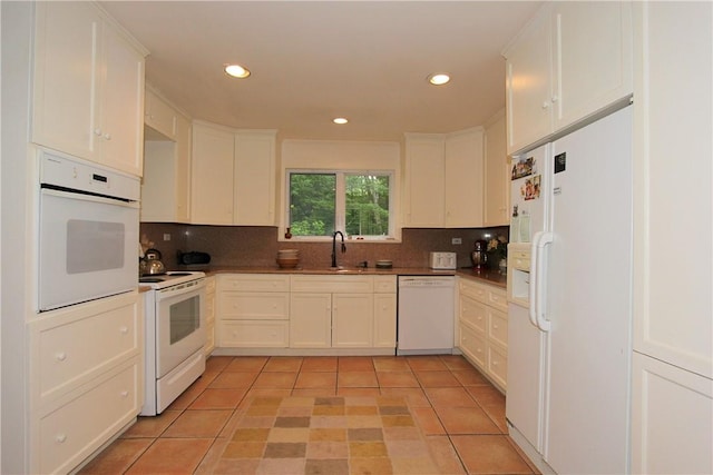 kitchen featuring backsplash, white cabinetry, light tile patterned flooring, and white appliances