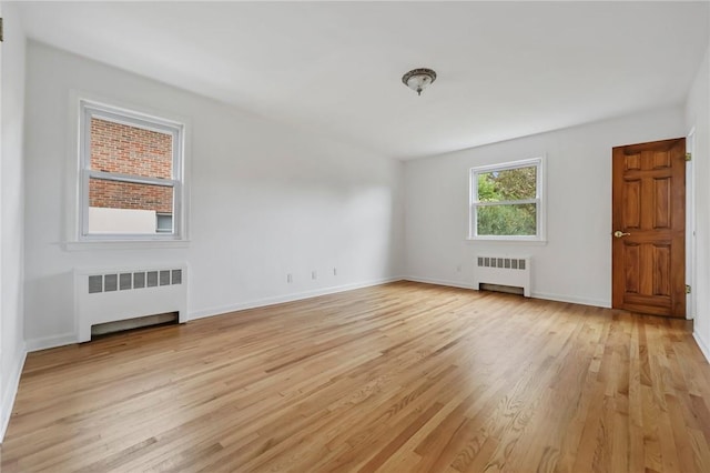 unfurnished living room featuring radiator and light hardwood / wood-style flooring