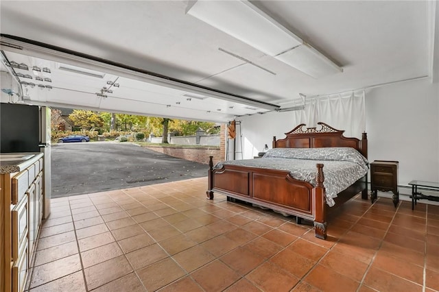 bedroom featuring stainless steel fridge and dark tile patterned floors