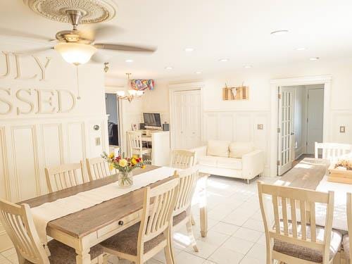 dining area featuring ceiling fan with notable chandelier and light tile patterned floors