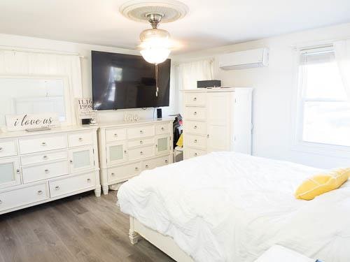 bedroom featuring a wall mounted AC, dark wood-type flooring, and ceiling fan