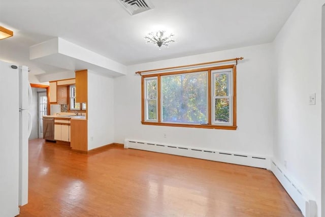 unfurnished living room featuring light hardwood / wood-style floors, a baseboard heating unit, and sink