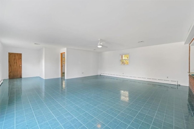 tiled spare room with a baseboard radiator and ceiling fan