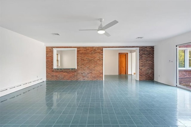 spare room featuring ceiling fan, baseboard heating, and brick wall