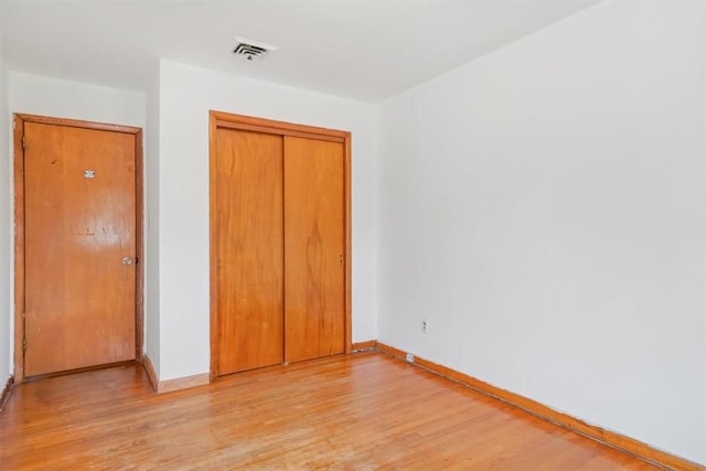 unfurnished bedroom featuring a closet and light hardwood / wood-style flooring