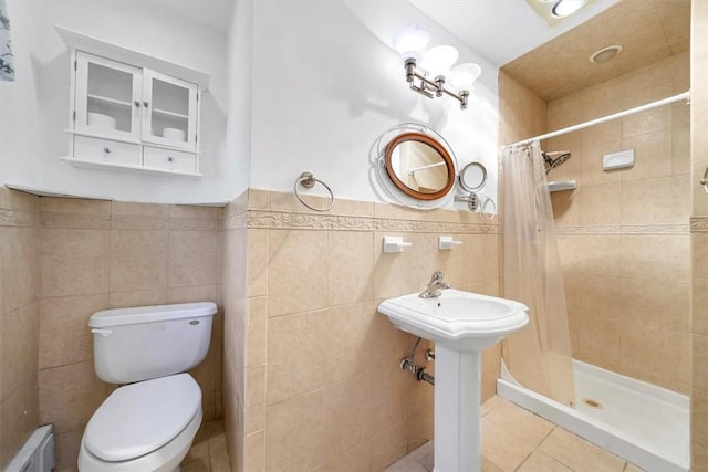 bathroom featuring curtained shower, sink, tile patterned floors, toilet, and tile walls