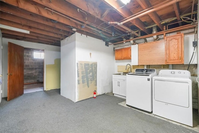 clothes washing area featuring sink, cabinets, and independent washer and dryer