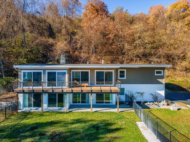 back of property with a lawn, a patio area, and a balcony