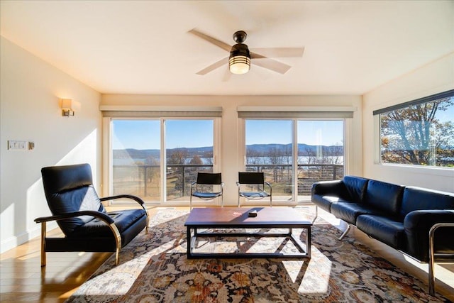 living room with a mountain view, ceiling fan, a healthy amount of sunlight, and hardwood / wood-style flooring