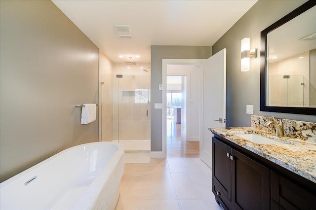 bathroom featuring tile patterned flooring, vanity, and shower with separate bathtub