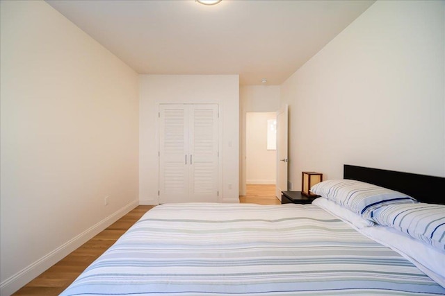 bedroom with light hardwood / wood-style flooring and a closet