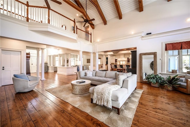 living room featuring decorative columns, high vaulted ceiling, dark hardwood / wood-style floors, and beam ceiling