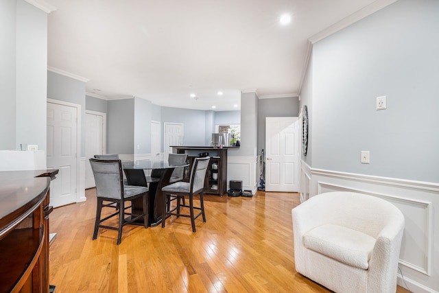 dining space featuring crown molding and light hardwood / wood-style floors