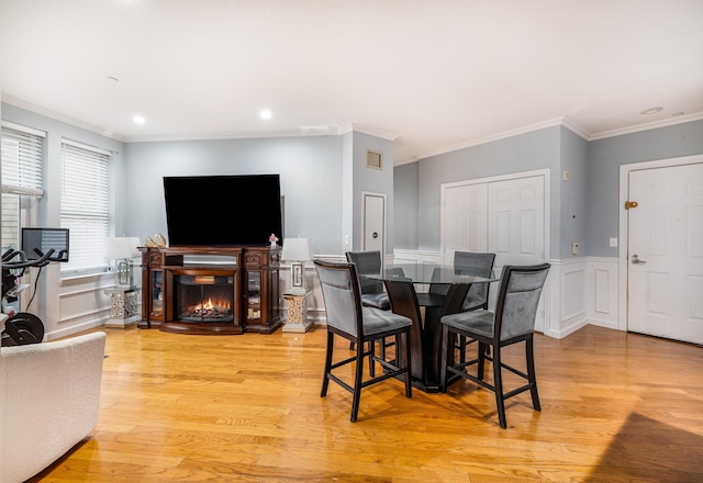 dining space featuring crown molding and light hardwood / wood-style floors