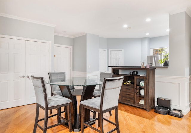 dining space featuring crown molding and light wood-type flooring