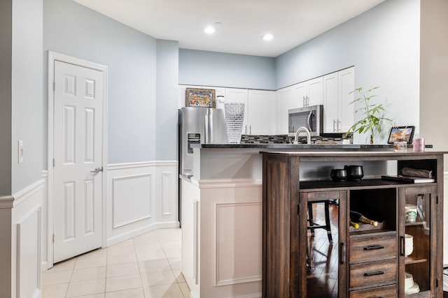 kitchen with sink, white cabinetry, stainless steel appliances, tasteful backsplash, and light tile patterned flooring