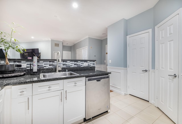 kitchen with sink, white cabinetry, light tile patterned floors, stainless steel dishwasher, and ornamental molding