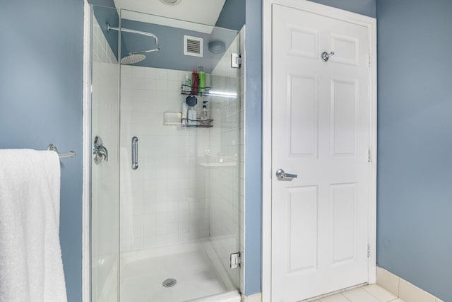 bathroom featuring a shower with door and tile patterned flooring