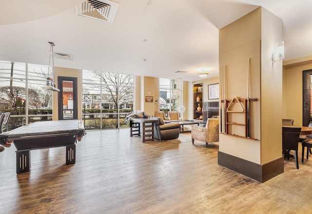 game room with hardwood / wood-style flooring, expansive windows, and billiards