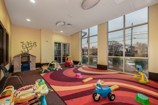 rec room with carpet floors and expansive windows