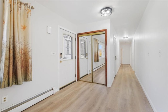 hallway featuring light wood-type flooring and baseboard heating