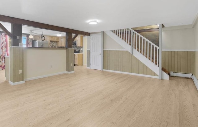 unfurnished living room featuring wood walls and light hardwood / wood-style floors