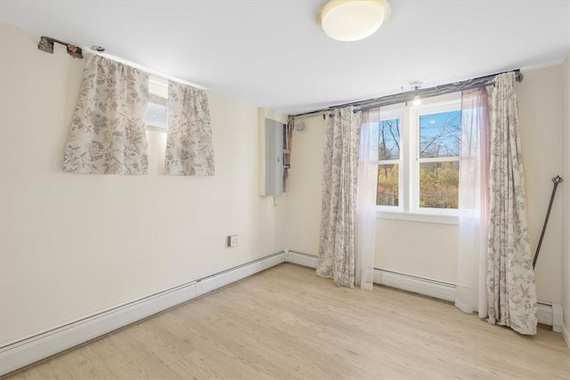 empty room with baseboard heating and light hardwood / wood-style flooring