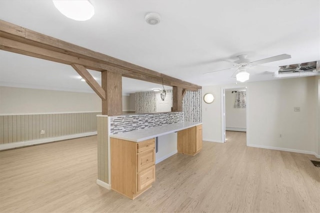 kitchen featuring light brown cabinets, hanging light fixtures, decorative backsplash, ceiling fan, and light hardwood / wood-style floors