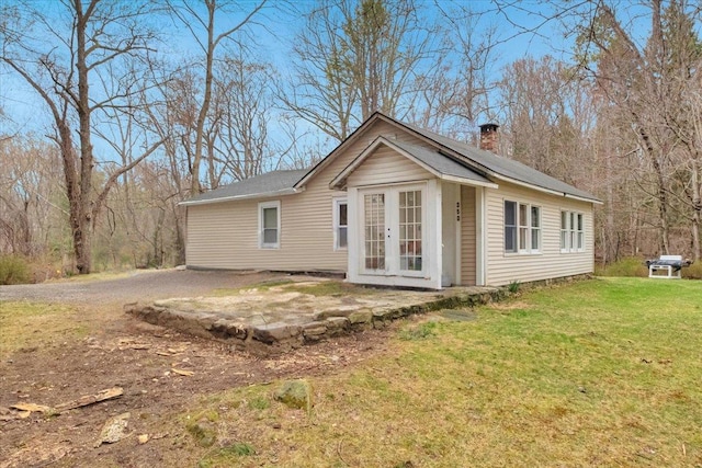350 W Shore Dr, Carmel, NY 10512 - view of front of home with french doors, a chimney, a front yard, and dirt driveway