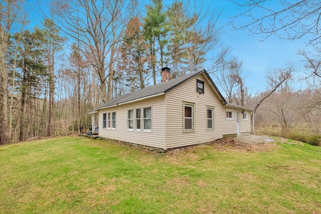 350 W Shore Dr, Carmel, NY 10512 - view of property exterior featuring a chimney and a lawn