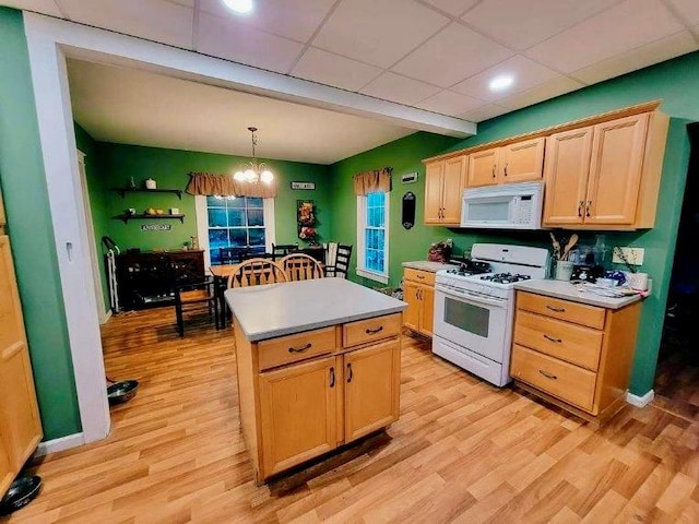 kitchen with white appliances, decorative light fixtures, an inviting chandelier, light hardwood / wood-style flooring, and a kitchen island