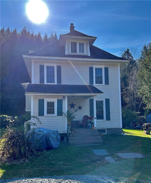 american foursquare style home with a chimney and a front lawn