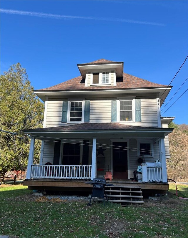 traditional style home featuring a porch and a front yard