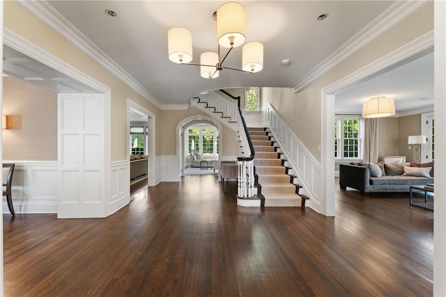 entryway with dark hardwood / wood-style flooring, crown molding, plenty of natural light, and a chandelier