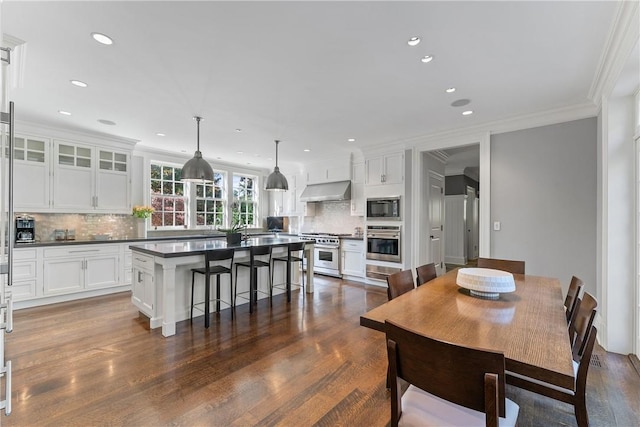 dining space with ornamental molding and dark wood-type flooring