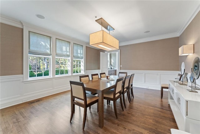 dining area with dark hardwood / wood-style flooring and crown molding