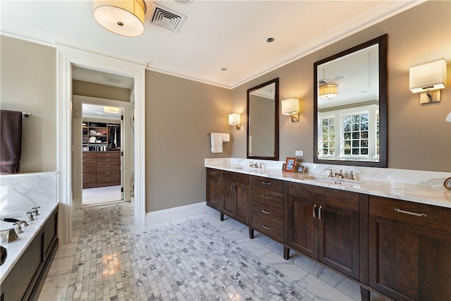 bathroom featuring a bathing tub, vanity, and crown molding