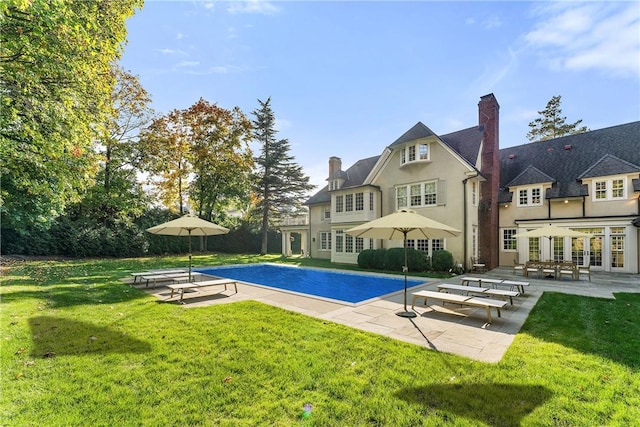 view of swimming pool featuring a yard and a patio