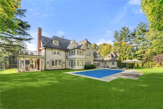 back of house featuring a lawn and a patio