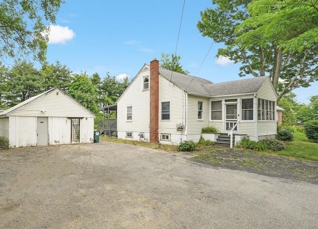 exterior space featuring a sunroom and an outbuilding