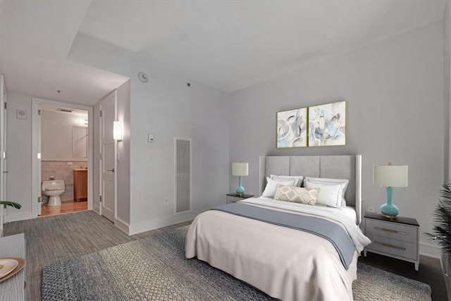 bedroom featuring ensuite bathroom and wood-type flooring