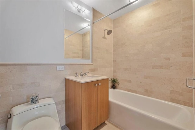 full bathroom featuring vanity, toilet, tile walls, and tiled shower / bath