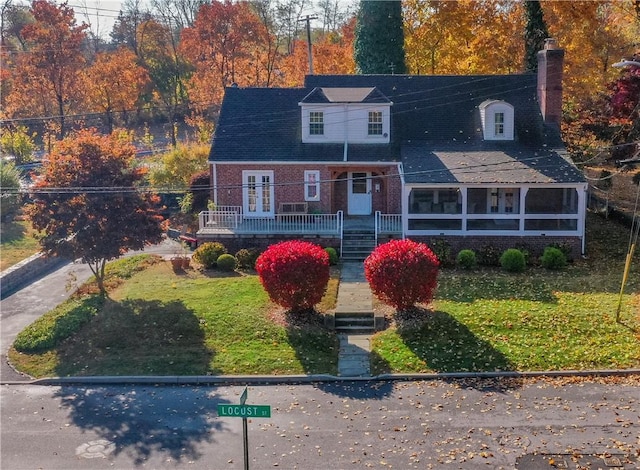 new england style home featuring a front yard