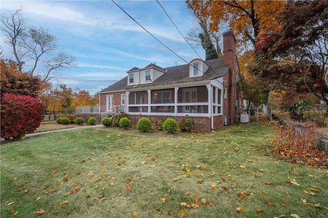 exterior space featuring a sunroom, cooling unit, and a front yard